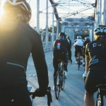 Gruppe von Radfahrern überquert in Zweierreihe eine Brücke