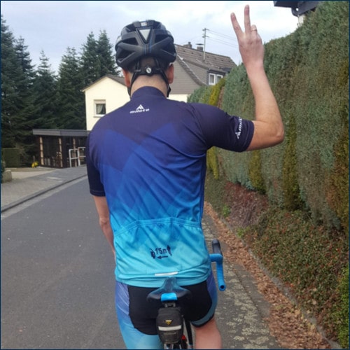 Radfahrer gibt Handzeichen für Formation in Zweierreihe