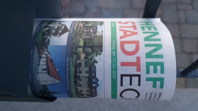 Eingerollte Lokalzeitung vom Hennefer Stadt Echo in einem Zeitungsrohr
