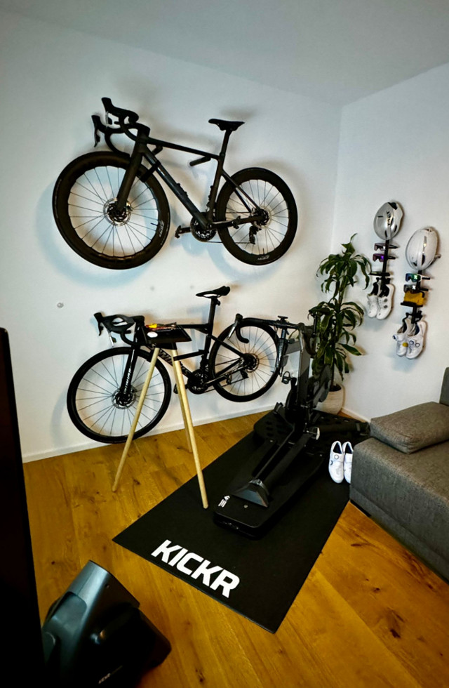 Rennräder und Fahrradhelme an einer Wand aufgehangen