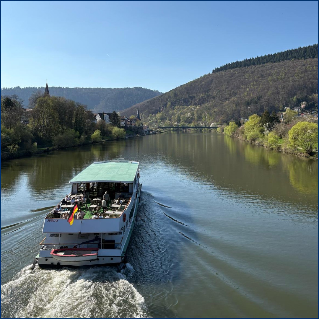 Landschaftliches Foto über den Neckar mit einem Boot im Vordergrund