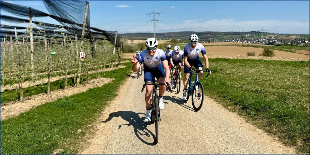 SCU Rennrad fährt auf einem Feldweg einen Hügel hinauf